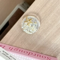 Detail of a phone grip with gold starfish and seashell resin inlay on wood table - Starry Sky Griptok Starfish Shell Stone / Off-white