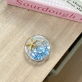 Macro view of ocean-themed phone grip with gold starfish and blue sea stones - Starry Sky Griptok Starfish Shell Stone / Sapphire Blue