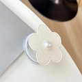Dettaglio macro del supporto per telefono a fiore crema con trama in pelle e perla - Fiore in pelle con piccole perle magnetiche / Bianco