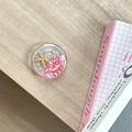 Detail of magnetic phone grip featuring sea stars and pink stones on wooden background - Starry Sky Griptok Starfish Shell Stone / Red