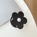 Primo piano del supporto per telefono a fiore in pelle nera con perla e cuciture fini - Fiore in pelle con piccole perle magnetiche / Nero
