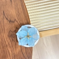 Détail du support téléphone fleur bleu clair avec centre doré sur bois de noyer - Bleu