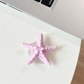Close-up of pink 3D starfish phone socket stand with textured surface on a white desk - Airbag Starfish / Light Purple
