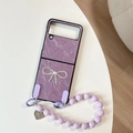 Dettaglio custodia pieghevole viola con fiocco di perle e cinturino con cuore - Viola Perlato (Con Catena A Cuore Con Fiocco)