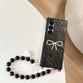 Detail of black leather folding phone case with rhinestone bow and bead wrist strap - Pearly Black (With Bow Heart Chain) / Samsung Z Flip 3