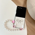 Close-up of white leather texture phone case with rhinestone bow and pearl wrist strap - Pearly White (With Bow Heart Chain) / Samsung Z Flip 3