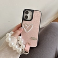 Detail of pink leather phone case with pearl heart and matching wristlet strap - Pearlescent Hollow Heart Bow Pearl Chain / Pink / iPhone 16e