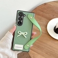 Green leather phone case for Samsung Z Flip with bow decor and wrist strap detail - Green