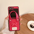 Detail of rose pink leather flip phone case with bow accent and convenient wrist strap - Rose Red