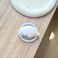 Nahaufnahme eines weißen Robben-Squishy-Handygriffs auf hellem Holzhintergrund - Magnetisch Squishy Robbe