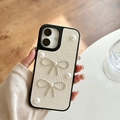 Close-up of pearl and diamond bow ornaments on elegant cream leather phone case - White / iPhone X/XS