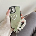 Dettaglio custodia in pelle verde chiaro con decoro cuore di perle e cinturino - Verde