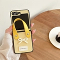 Detail of yellow leather fold phone case with 3D white bow and integrated hand strap - Yellow / Samsung ZFlip3