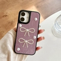 Detail of purple pleated leather phone case with silver bows and white pearl accents - Purple