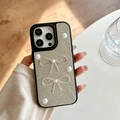 Detail of champagne gold leather phone case with pearl accents and rhinestone bows - Silver
