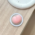 Close-up of a soft pink heart-shaped squishy phone grip on a clear acrylic base - Magnetic Squishy Butt