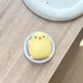 Close-up of yellow cartoon chick stress relief toy on transparent phone grip stand - Magnetic Squishy Chick