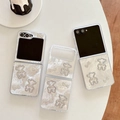 Witte parelmoer Z Flip 6 hoesje met strass-beertje en strik op een witte tafel - Sterrenhemel Druppelende Lijm Strass Boog Beer Stijl / Samsung ZFlip3