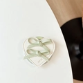 Detail of light green bow hair clips on white leather card with HAVE A NICE DAY text - Green
