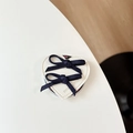 Detail der herzförmigen Leder-Handyhalterung mit blauen Schleifen und Prägung - Schwarz