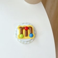 Dettaglio del supporto per telefono 3D giallo con lettera M e decorazioni a sfere colorate - Confetto al Cioccolato con Lettera M (Giallo)