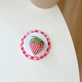 Detailed top view of a fabric strawberry emblem on red gingham circular base - Strawberry Style (Red)