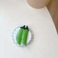 Macro view of green pea pod shaped magnetic phone stand on a minimalist round base - Sweet Pea Style (Green)