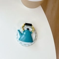 Macro top view of miniature teal teapot phone grip with golden handle on a tray - Kettle Style (Grey Green)