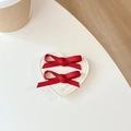 Dettaglio di fiocco in nastro rosso su patch in pelle a cuore con testo Have a Nice Day - Rosso