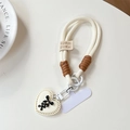 Detail der handgewebten Handykette mit cremefarbenem Herz und schwarzer Schleife - Smile Kurzes Seil + Weißer Patch + Gebundenes Herz / Weiß