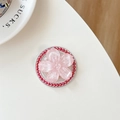 Macro view of flower-shaped phone grip with pearlescent pink petals and red beads - Red Glitter Sakura Cat Paw