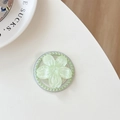 Macro shot of light green flower phone grip with pearl accents and shimmering finish - Light Green Glitter Sakura Cat Paw