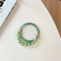Sparkly green glitter phone socket with faceted crystal bead strap on white desk - Green Glitter + Green Crystal Chain
