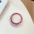 Macro detail of red glitter acrylic phone grip with purple faceted bead tassel charm - Rose Red Glitter + Purple Crystal Chain