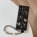 Detail of black sparkle phone case with bows and luxury pearl rhinestone lanyard - Black / Samsung ZFlip3