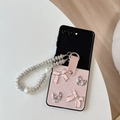Detail of light pink foldable phone case with pearl strap and elegant bow accents - Pink / Samsung ZFlip3