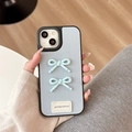 Detail of light blue lychee leather phone case with 3D bows and goodgoodluck label - Large-pore Leather Texture - Good Polka Dot Bow - Light Blue / iPhone X/XS