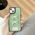 Detail of green lychee leather iPhone case with 3D bows and 'goodgoodluck' label - Large-pore Leather Texture - Good Polka Dot Bow - Green / iPhone X/XS