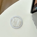 Close-up of pearl magnetic bow phone grip on desk showing delicate texture and elegant design - White