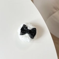 Detail of plush bear phone socket featuring a black rhinestone bowknot on white faux fur - Plush Rhinestone Bowknot Shape / Black