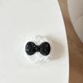 Detailed close-up of a plush knit bow accessory with sparkling black rhinestones - Plush Rhinestone Round Bowknot Shape / Black