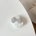 Close-up of plush bear phone socket with sparkling rhinestone bow on soft white base - Plush Rhinestone Round Bowknot Shape / White