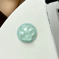 Detailed view of mint green cat paw phone grip with crystal border on a white table - Shimmering Green