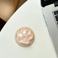 Detail der rosa Katzenpfoten-Handyhalterung mit Herzrelief und Goldperlen-Rand - Schimmerndes Orange