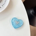 Detailed close-up of light blue glitter heart phone grip with metallic silver logo inlay - Blue Flash / Labradorite