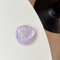 Détail d'un support de téléphone cœur pailleté violet avec perles et logo métallique - Paillettes Violettes (Perle Magnétique Coeur 3D)