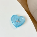 Macro detail of heart-shaped phone grip in light blue resin with rhinestone cherry inlay - Blue Glitter (3D Heart Rhinestone Cherry)