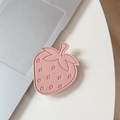 Dettaglio del supporto per telefono in pelle a fragola con cuciture su un tavolo - Rosa