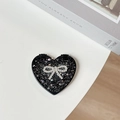Close-up of black glitter heart-shaped compact mirror with a rhinestone bow on white desk - Starry Silver Foil Bow #3 / Black