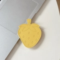 Macro detail of strawberry-shaped yellow leather phone grip with lychee texture and stitching - Yellow